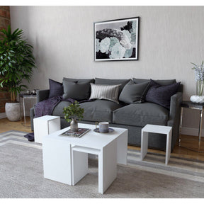 Set de 3 măsuțe albe într-un living modern, alături de o canapea gri – primabucata